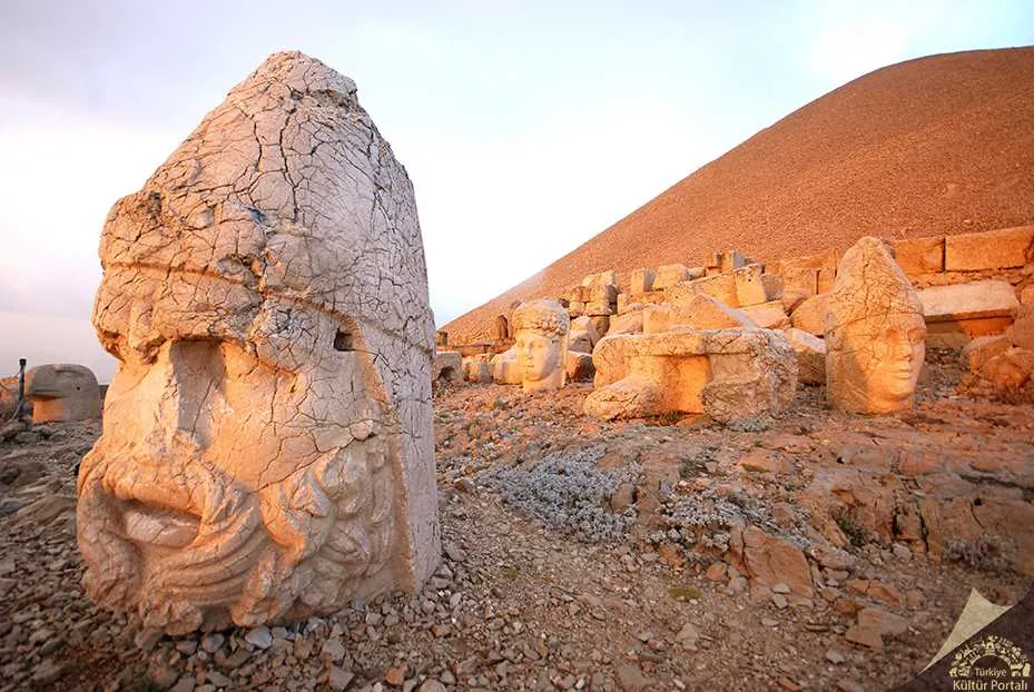 Taş heykel başı ve arkada tümülüs