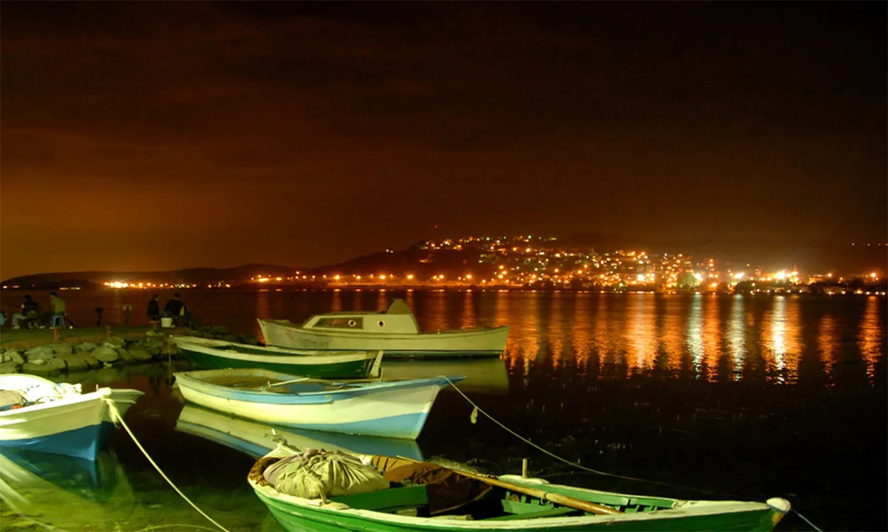 Gece ışıkları ve kıyıya bağlı kayıklar